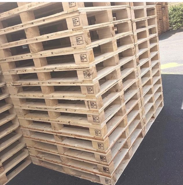 Stacked wooden block pallets with visible treatment marks