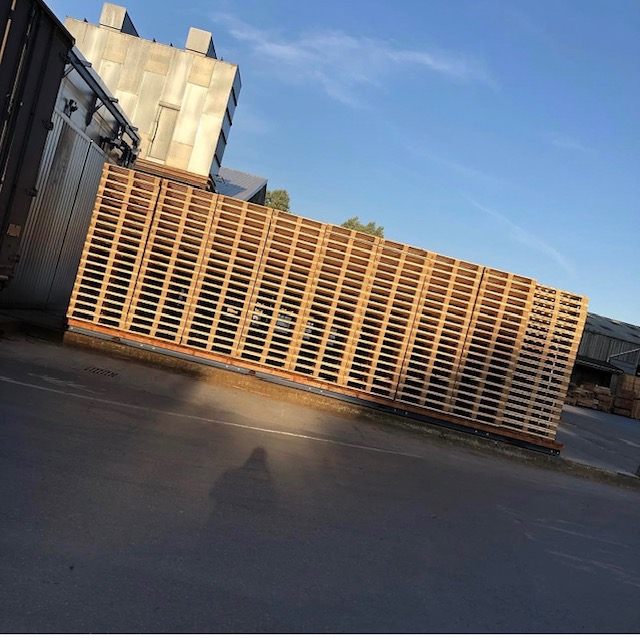 Wooden pallet stacks in an outdoor yard